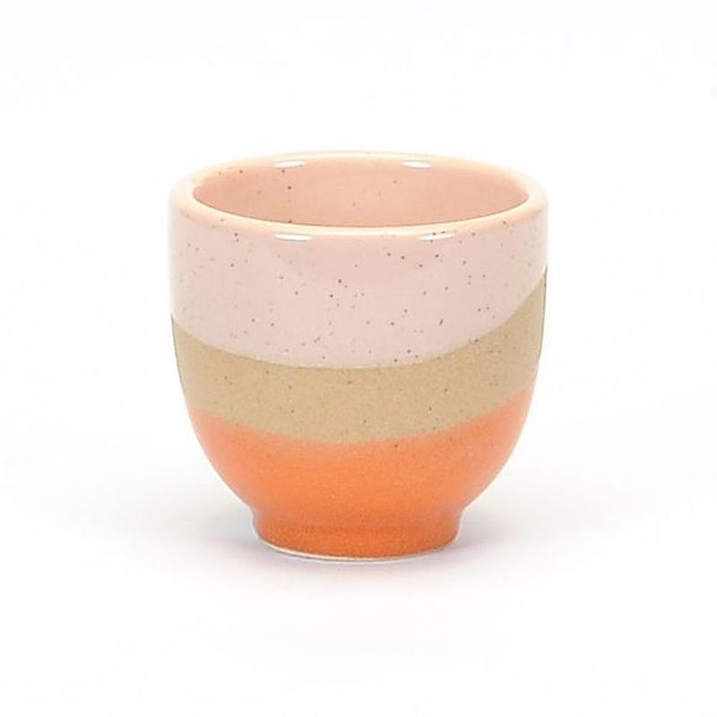 Small Bright Raised Base Pot - Orange/Pink/Sandstone by MyHomeDecor.ca with a rounded shape, featuring a tricolor design: the top section is pale pink, the middle section resembles sandstone finish in a beige sand color, and the bottom section is a vibrant orange. The surface has a smooth, shiny finish and light speckling in the pink area.